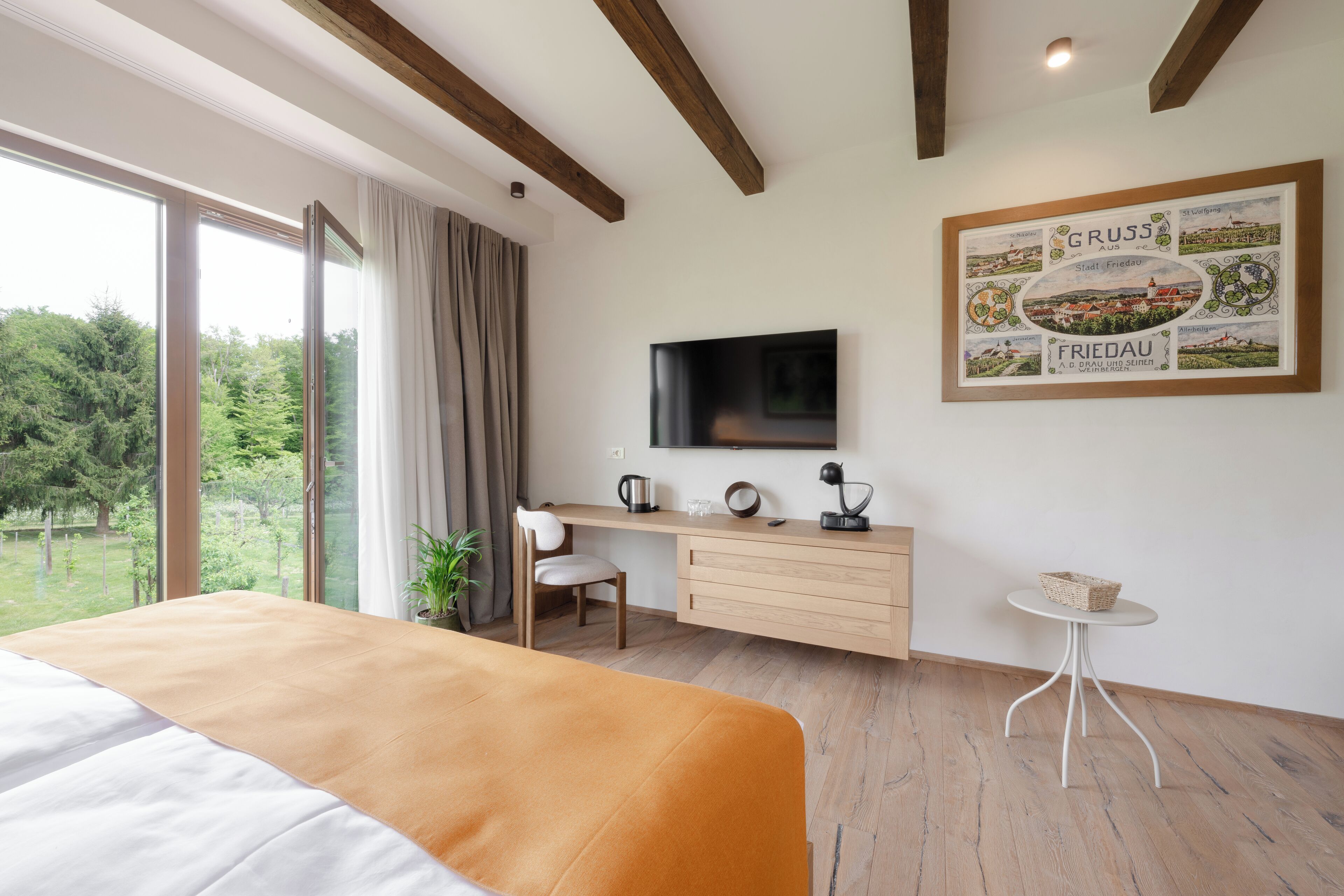 Une chambre à coucher avec un lit, un bureau, une chaise, une télévision et une carte encadrée accrochée au mur.