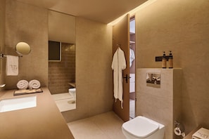 Une salle de bain moderne équipée d’une baignoire, de toilettes et d’un espace douche.