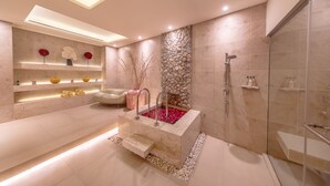 Un baño moderno con una bañera independiente, una ducha con cerramiento de vidrio y un tocador con estantes.