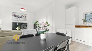 A modern kitchen with white cabinets, a black countertop, and a red pendant light. - Exclusive 2 Bedroom Flat near Loughborough Junction! (Greater London)