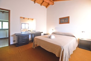 A bedroom with a bed, bedside tables, a dresser, a mirror, and a framed picture on the wall. - Casa Letizia (Colico)
