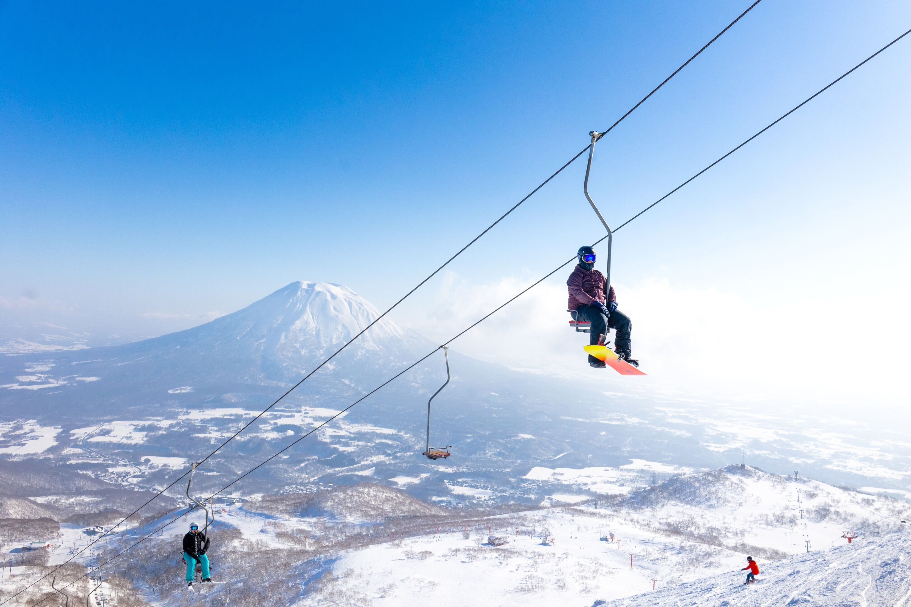 A ski lift with a snowy mountain in the background.