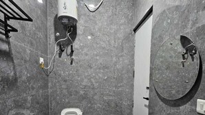 Une salle de bain moderne équipée de toilettes, d’un lavabo et d’un miroir.