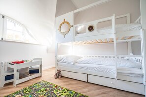 A bunk bed room with a window, a desk, and a colorful rug. - Vacation home Haubenlerche 53 - Boddenglück - Holiday home Haubenlerche 53 - The (Fuhlendorf)