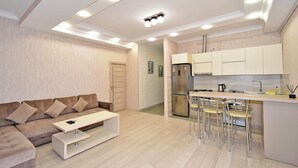 Eine moderne Wohnung mit Wohnbereich, Küchenzeile und Essplatz.