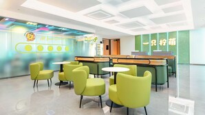 A modern hotel lobby with green chairs and tables, a reception desk, and a neon sign. - Lemon Hotel- New World Shopping Mall (Wuhan)