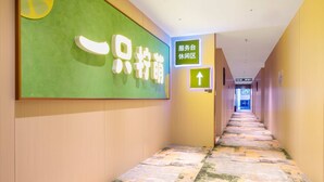 A hotel corridor with directional signs and a patterned floor. - Lemon Hotel- New World Shopping Mall (Wuhan)