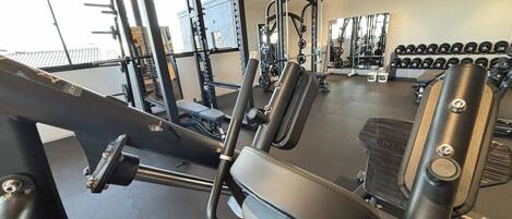 Un gimnasio con equipo de ejercicio variado, que incluye máquinas de pesas y pesas libres.