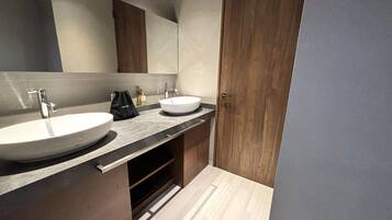 Un bagno moderno con due lavabi, uno specchio grande e mobili in legno.
