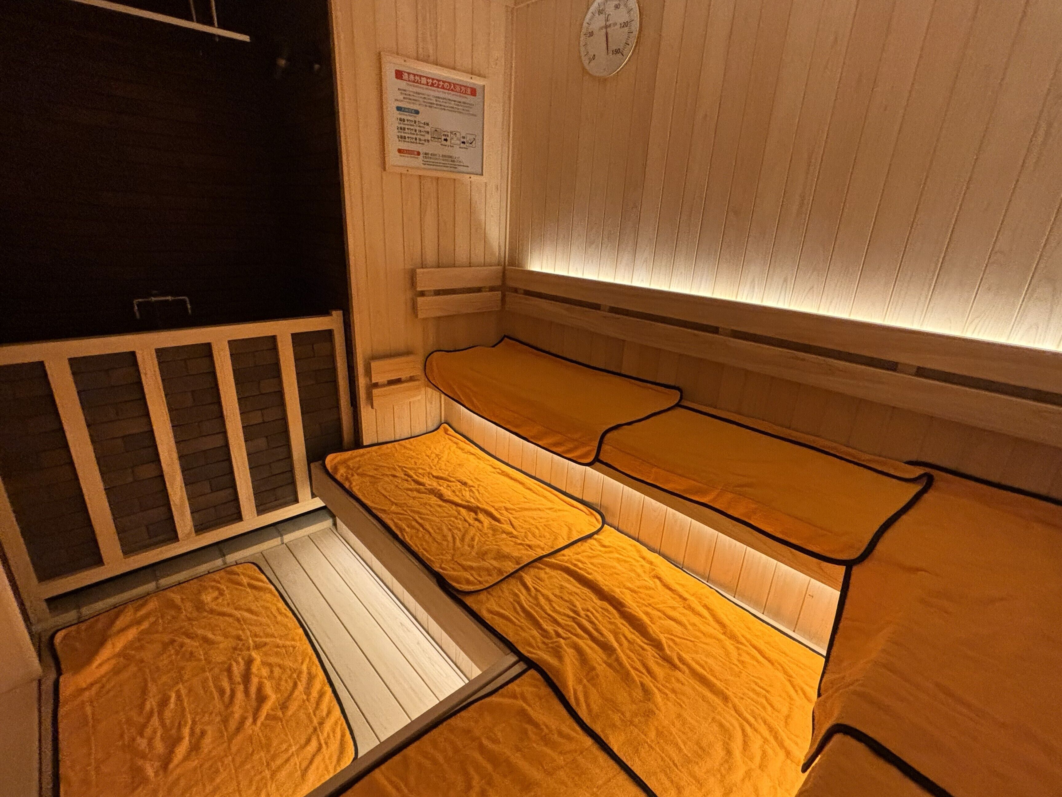 A sauna room with wooden benches and a wooden floor.