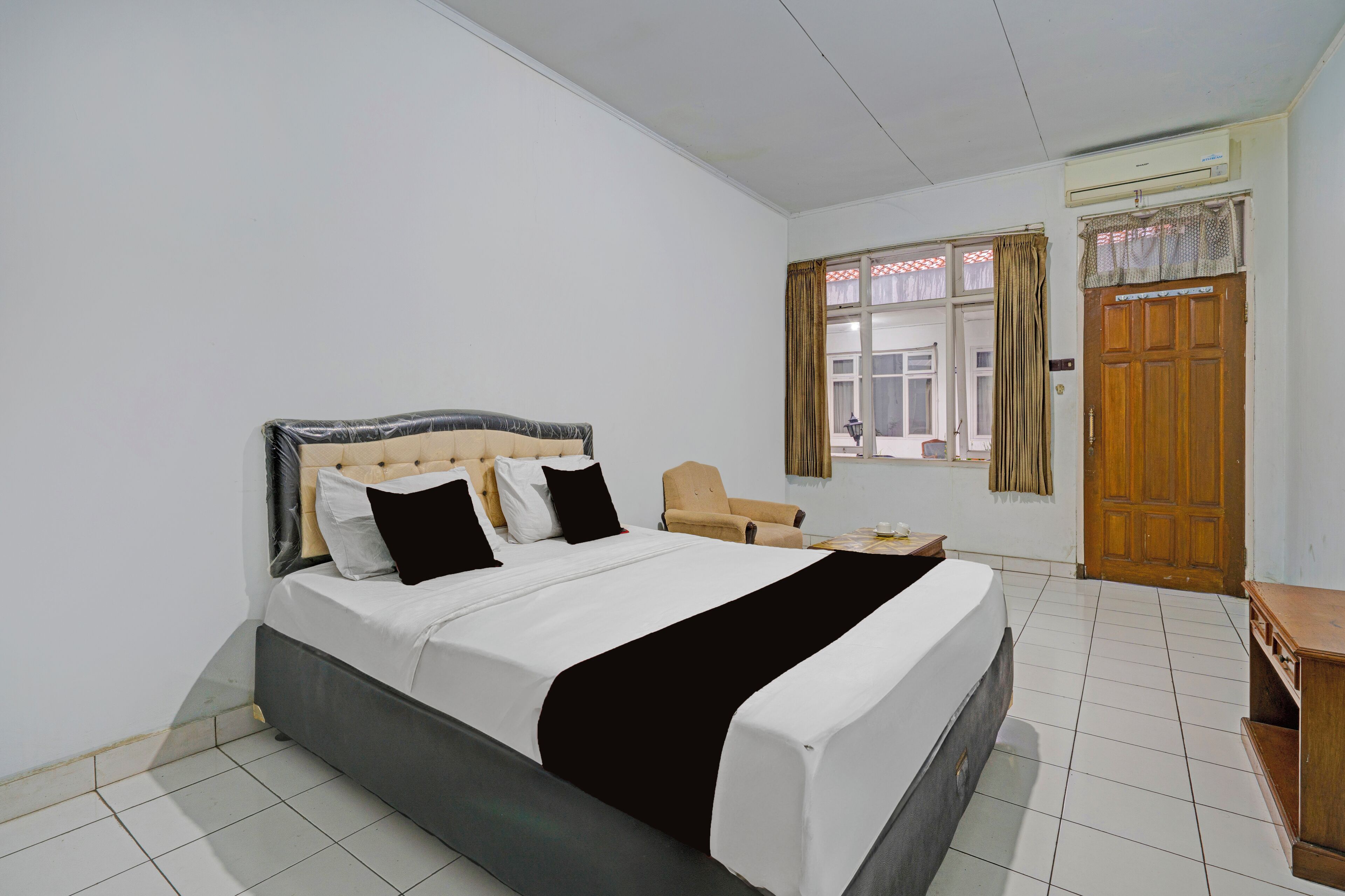 Une chambre bien rangée, avec un lit, une chaise et une petite table.