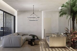 A modern living room with a sectional sofa, a round coffee table, and a hanging light fixture.