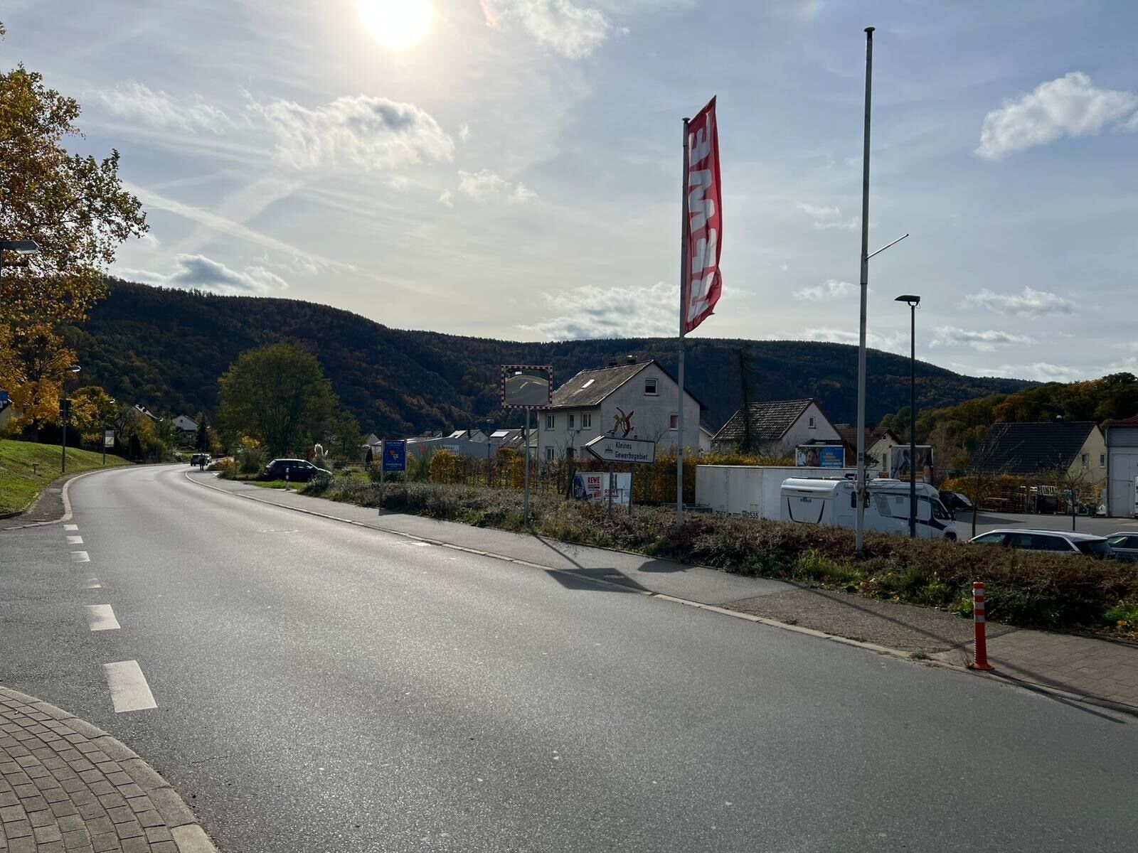 A road with houses on one side and a mountain in the background.