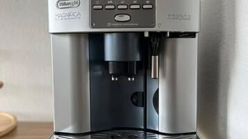 Een strakke, moderne espressomachine met een digitaal scherm en meerdere bedieningsknoppen, op een wit aanrecht.
