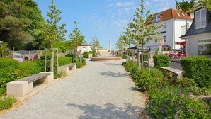 A paved pathway leading to a central fountain, surrounded by greenery and benches. - Relaxing beach vacation at Villa Daheim in Breege-Juliusruh (Juliusruh)