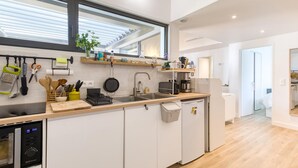 A modern kitchen with a built-in oven, a sink, and a countertop with various appliances and utensils. - Maison accès plage direct (Meschers-sur-Gironde)