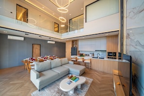 Eine moderne Wohnung mit Essbereich, Küche und Wohnzimmer mit Sofa und Couchtisch.