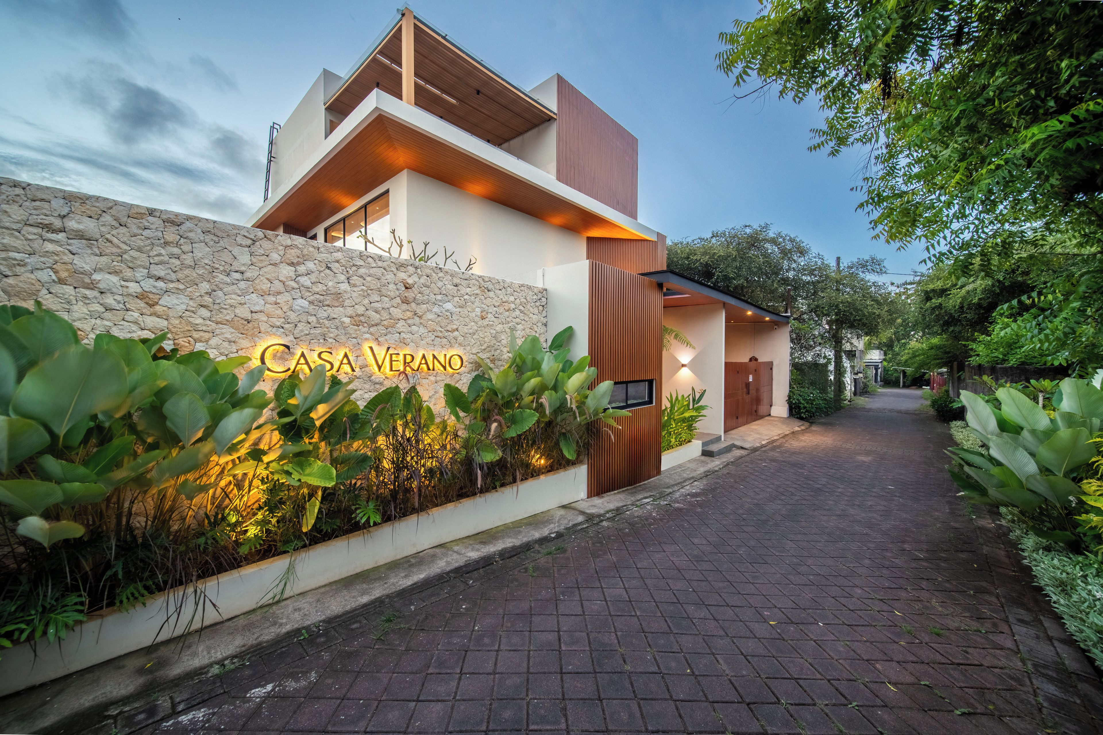 Un edificio moderno con fachada de piedra y un cartel que dice 'Casa Verano'.