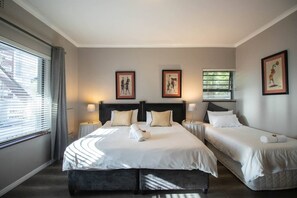 Una camera d'albergo con un letto grande, due comodini e una finestra con tende.