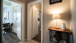 A hallway with a dining area, a lamp, and a framed picture on the wall. - Spring Tide Inn - Standard Family Room 2 (Cape Town)