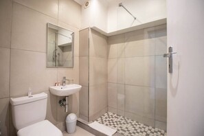 Un bagno moderno con servizi igienici, lavandino e cabina doccia in vetro.