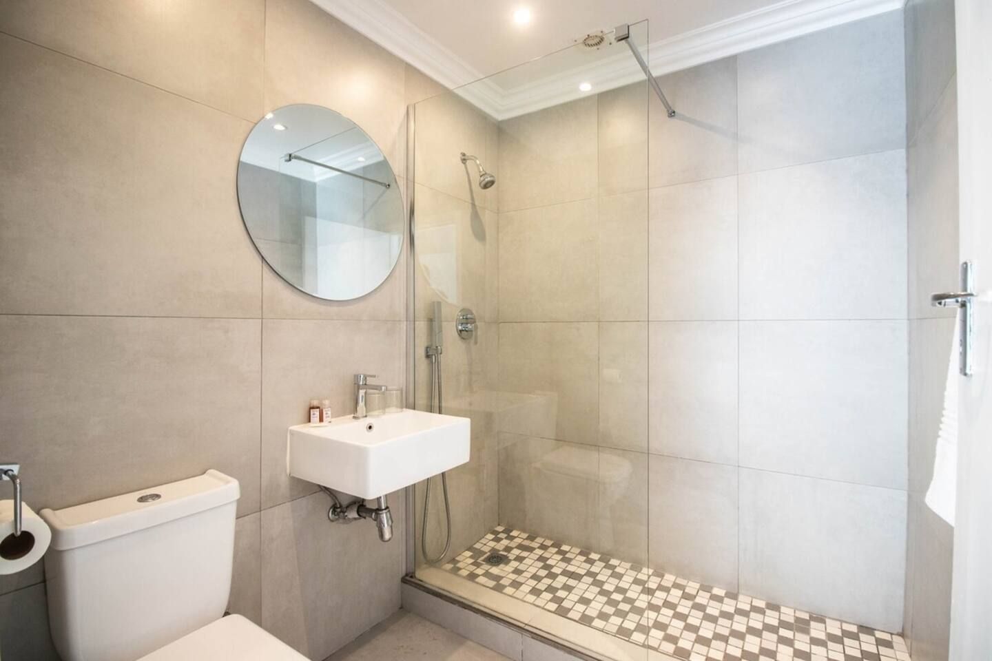 A bathroom with a toilet, a sink, and a shower.