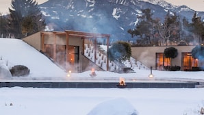A modern building with a snow-covered landscape and mountains in the background. - Seehof Nature Retreat (Naz Sciaves)