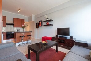 A modern apartment with a kitchen, dining area, and living room.