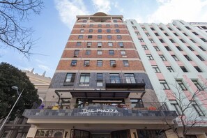 A multi-story building with a sign for 'The Pizza on Church Square.'