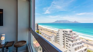Un balcone con vista sull'oceano e una montagna all'orizzonte.