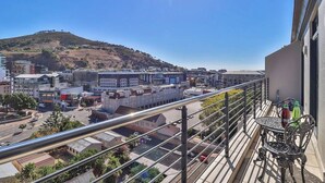 A balcony with a view of a cityscape, including buildings and a hill. - Quayside 1206 by Ctha (Cape Town)