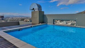 Una piscina en la azotea con vistas despejadas al paisaje urbano y una estructura en forma de cúpula.