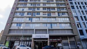 Un edificio de varios pisos con un letrero que dice 'PERSPECTIVES'.