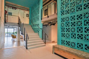 A staircase with a geometric patterned wall on the right and a plain wall on the left.