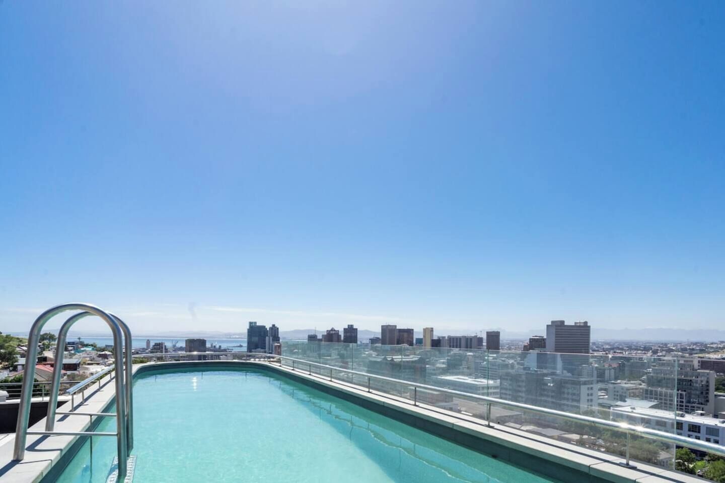 Una piscina en la azotea con vista al horizonte de la ciudad.