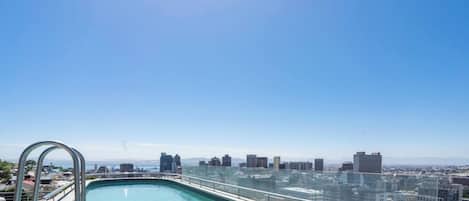 Una piscina en la azotea con vista al horizonte de la ciudad.
