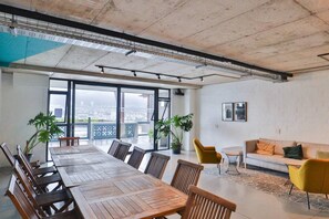 A modern conference room with a large table, chairs, and potted plants.