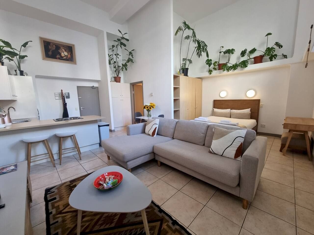 A modern living space with a sofa, dining area, and kitchen.