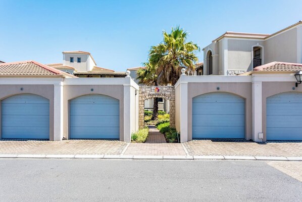 A residential area with two-story houses, each with a garage door and a small entrance.
