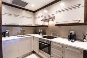 A modern kitchen with stainless steel appliances, a built-in oven, and a coffee maker.