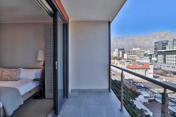 A balcony with a bed and a city view.
