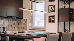 Una cocina moderna con una mesa de comedor, sillas e iluminación colgante.