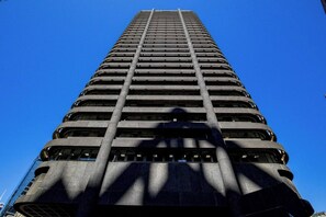 Un edificio alto e moderno con una serie di balconi e un colonnato centrale.