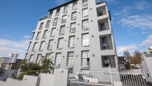 A multi-story residential building with balconies, a gated entrance, and a clear sky. - Harbour Terrace 48 by Ctha (Cape Town)