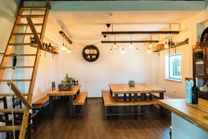 Un intérieur rustique avec des meubles en bois, une échelle et des luminaires suspendus.