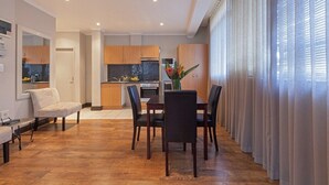 Ein modernes Wohnzimmer mit Essbereich, Holzböden und einer Küche im Hintergrund.