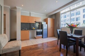 Une cuisine de taille réduite, avec des meubles de rangement en bois, une cuisinière et un réfrigérateur.