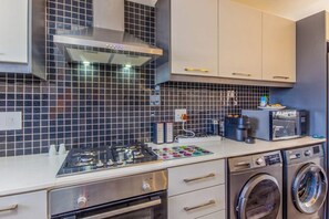 A modern kitchen with a gas stove, microwave, and built-in oven.