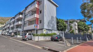 A multi-story residential building with balconies, a parking area, and a gated entrance. - Eaton Square 2 by Ctha (Cape Town)