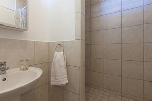 Een badkamer met een wastafel, spiegel en handdoekhouder.